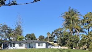Une maison de plain-pied avec un toit en pente, un porche à l’avant et un garage.