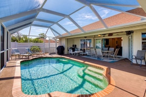 A covered outdoor swimming pool with lounge chairs and a patio area. - Gulfstream Villa | Heated Pool + Dog Friendly (Englewood)