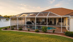 A covered patio area with a pool, seating, and a barbecue grill. - Gulfstream Villa | Heated Pool + Dog Friendly (Englewood)