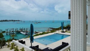 A pool area with a view of the sea and boats. - Beautiful modern Harbour house with amazing Sunset Views ! (Black Point, Great Guana Cay)