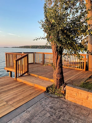 A wooden deck with a railing overlooking a body of water.