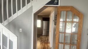 A staircase leading to a kitchen area with a wooden door and a view of the interior. - Fantastic Lake Views and Gorgeous Sunsets All year round (Nestleton Station)