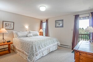 A bedroom with a bed, bedside lamps, a nightstand, a window with curtains, and a view of the outdoors. - 2 Br: Powderidge17: Slope Side. on the shuttle route. clean and spacious! (Snowshoe)