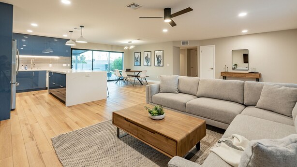 A modern living room with a sofa, coffee table, and a dining area with chairs. - Beautiful Three Bedroom in the Center of Phoenix (Phoenix)