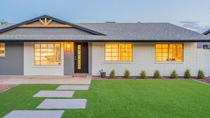 A modern two-story house with a grey roof, white brick exterior, and a well-maintained lawn. - Beautiful Three Bedroom in the Center of Phoenix (Phoenix)