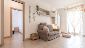 Un salon avec un canapé, une petite table, un panier et une plante.