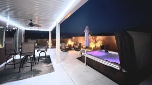 Eine Außenpatio-Terrasse mit überdachter Sitzgruppe, einem Grill und einem beheizten Außenpool.