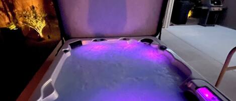 A hot tub with a digital control panel and LED lighting.
