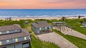 A beachfront property with a house, a covered patio, and a view of the ocean. - Beachfront | Firepit, Volleyball & Gazebo Dining (Port Bolivar)