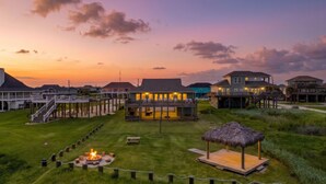 A beachfront property with a pool, a fire pit, and a thatched-roof structure. - Beachfront | Firepit, Volleyball & Gazebo Dining (Port Bolivar)