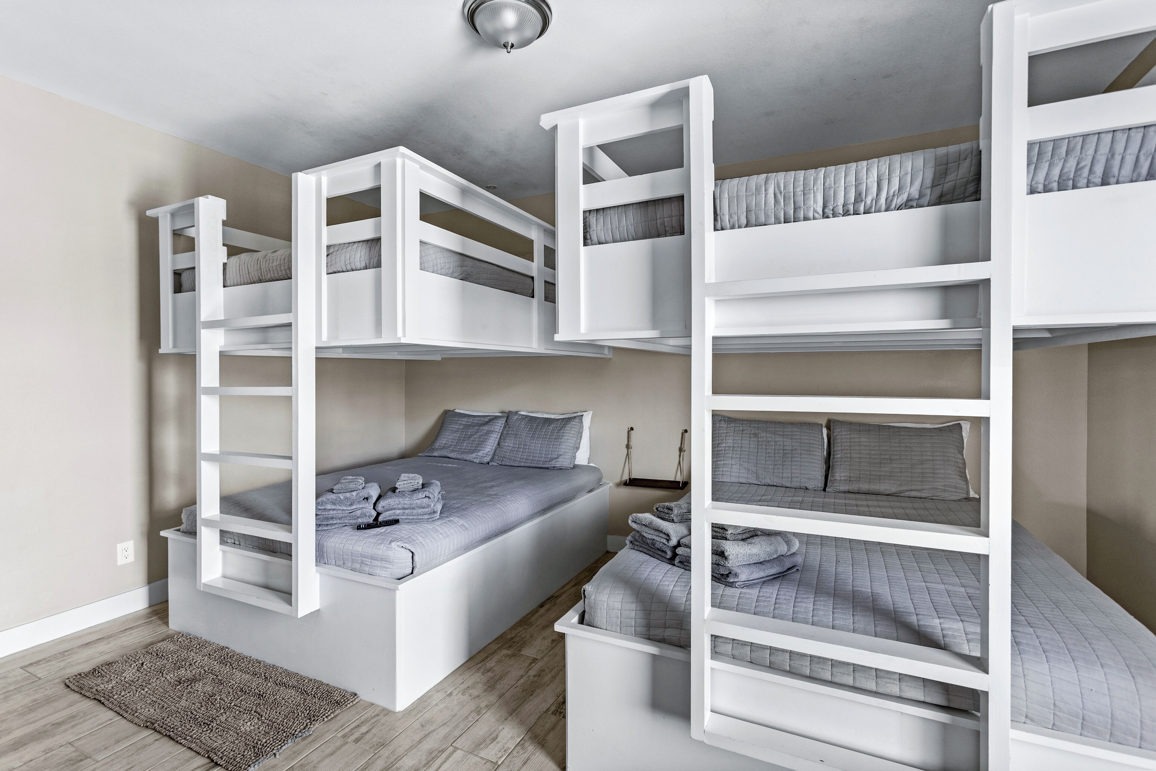 A room with bunk beds, a small rug, and a ceiling light fixture.