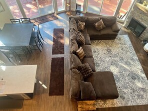 A modern living room with a sectional sofa, a dining table, and a fireplace. - Secluded Mountain Home in the Pines (Flagstaff)