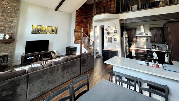 A spacious living area with a large sofa, a flat-screen TV, and a wooden ceiling. - Secluded Mountain Home in the Pines (Flagstaff)