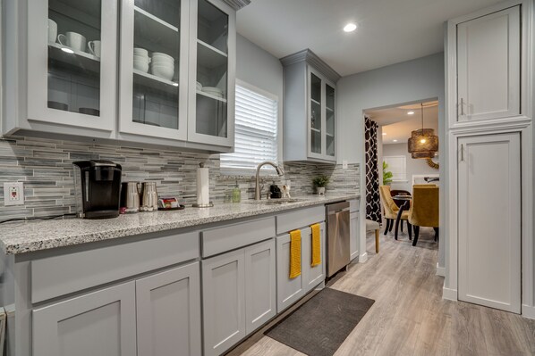 Enjoy meal preparation and socializing in this well-equipped kitchen with a dishwasher, sink, and kitchen essentials.
