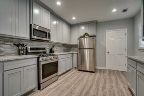 Enjoy cooking in this well-equipped kitchen with a microwave, oven, and refrigerator.