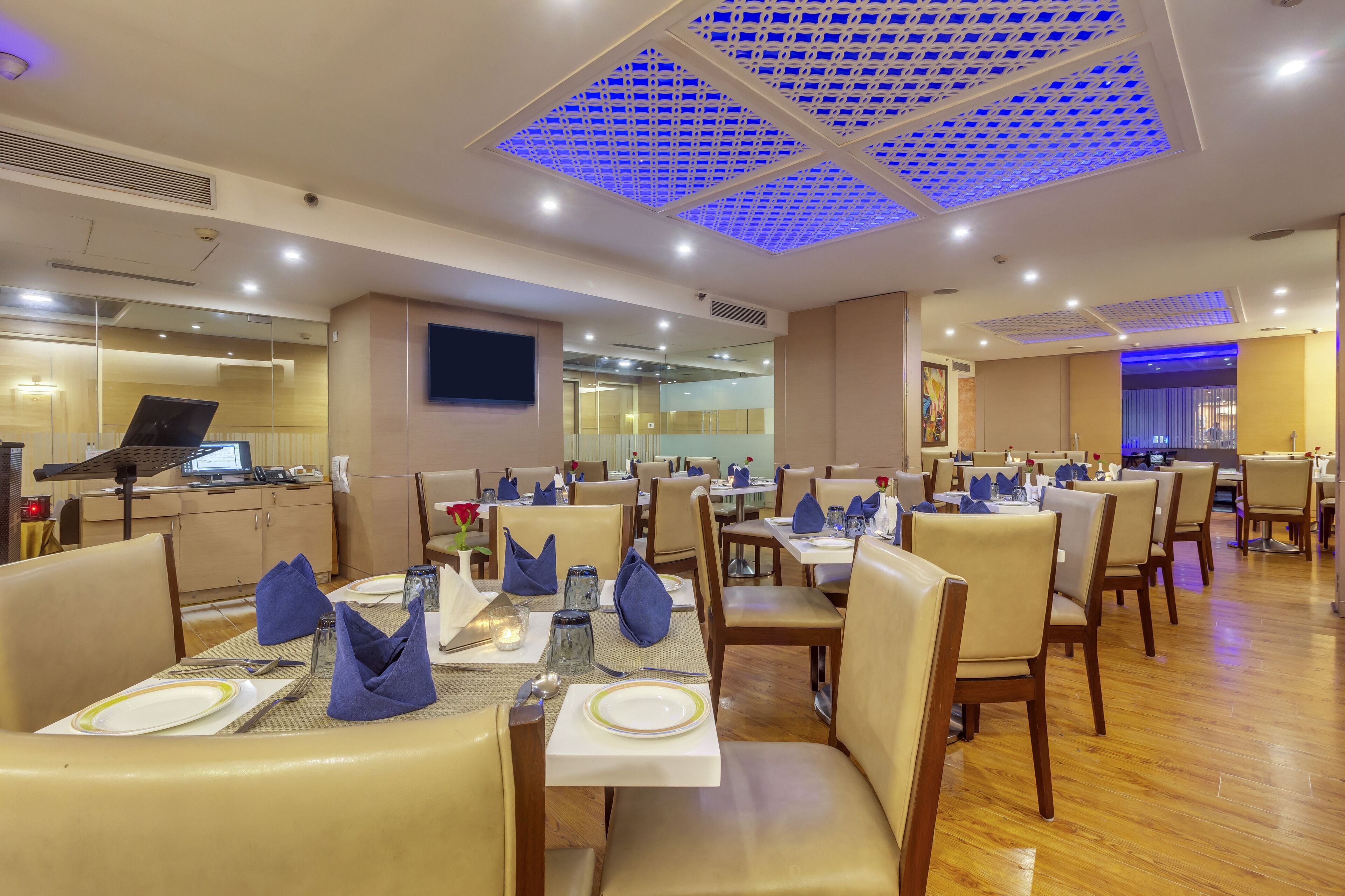 Un restaurante con mesas dispuestas para comer, provistas de servilletas, cubiertos y vasos.