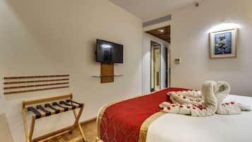 Relax in a stylishly designed room with a comfortable bed, flat-screen TV, and a cozy bench.