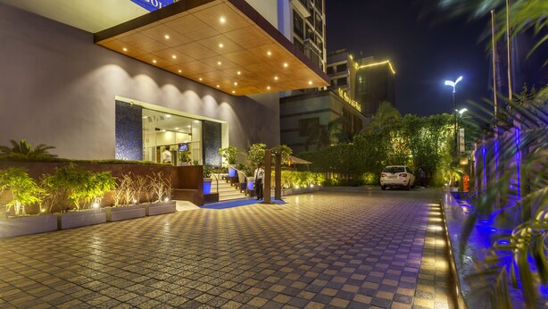 A hotel entrance with a tiled pathway, a covered waiting area, and a visible entrance door. - Golden Tulip New Delhi - Hari Nagar (New Delhi)