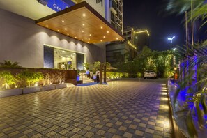 A hotel entrance with a tiled pathway, a covered waiting area, and a visible entrance door. - Golden Tulip New Delhi - Hari Nagar (New Delhi)