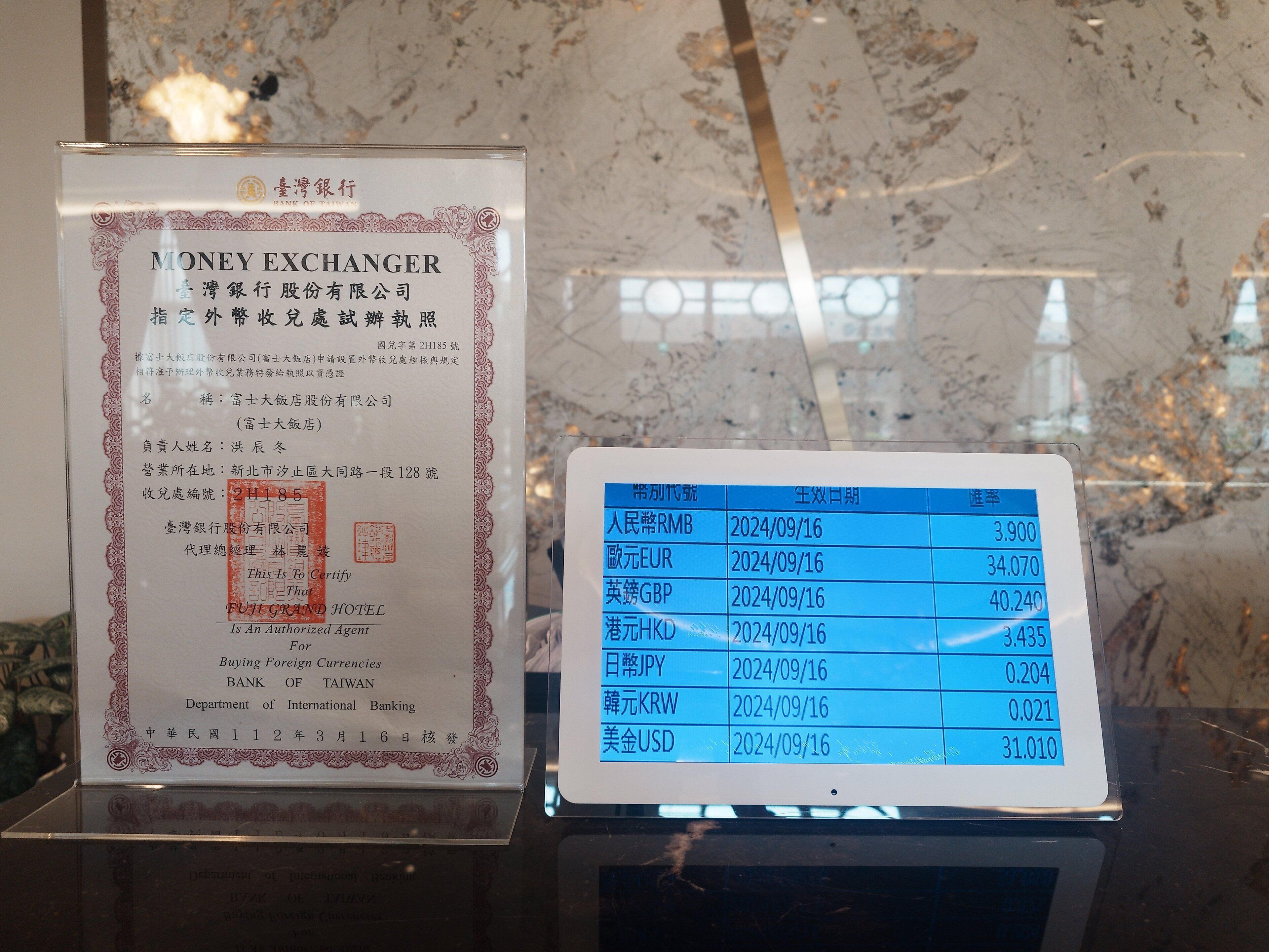 A money exchanger sign with a table listing exchange rates for various currencies as of 2024/09/16.