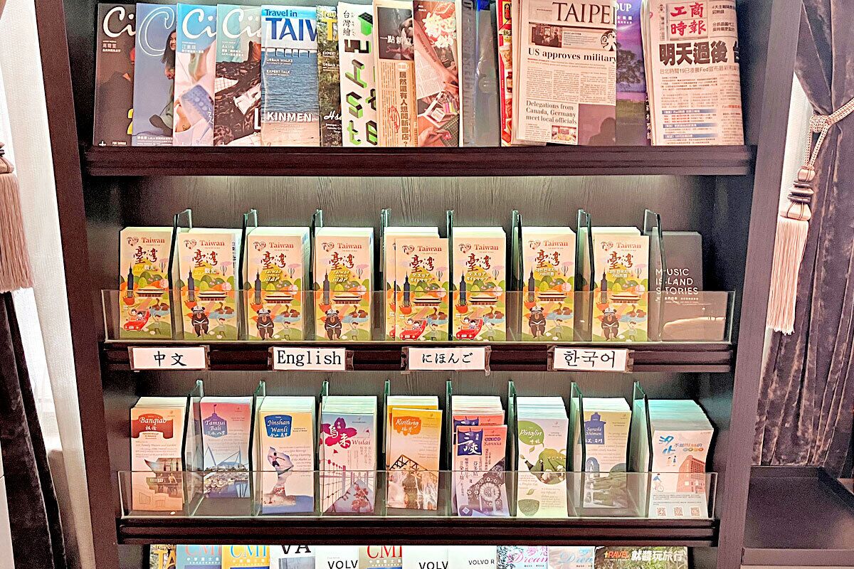 A travel information shelf with books and pamphlets.