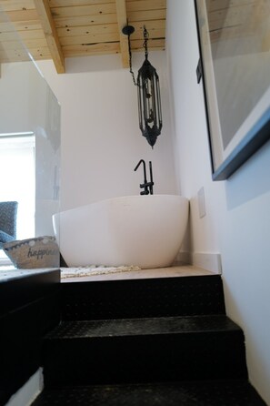 A bathroom with a freestanding bathtub, a wooden ceiling, and a hanging lantern. - Casa Alana (Polientes)