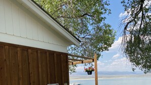 A wooden building with a caution sign, a wooden staircase, and a view of a body of water. - Tioga Lodge At Mono Lake (Lee Vining)