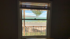 A room with a large window overlooking a road and a body of water. - Tioga Lodge At Mono Lake (Lee Vining)