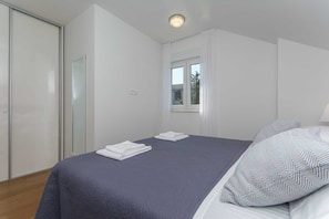 A bedroom with a bed, a window, and a door. - Apartment Gloria (Dubrovnik)