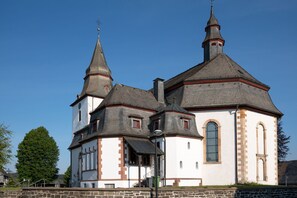 A church with a white facade, two towers, and a clock.