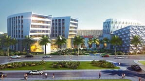 A modern hotel with a curved facade, palm trees, and a central courtyard. - IntercityHotel Muscat (Muscat)