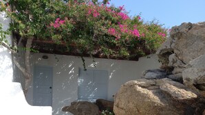 A white building with a blue door, large rocks, and a potted plant. - Breathtaking views (Plintri)