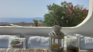 A balcony with a view of the sea, white cushions, and a lantern with a star design. - Breathtaking views (Plintri)