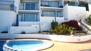 A multi-story hotel with blue balconies and a swimming pool. - Arabella duplex village (Peñiscola)