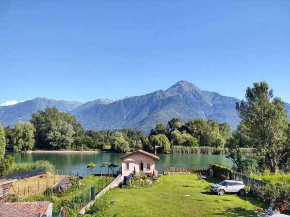 A house with a view of a lake and mountains in the background.