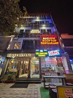 A hotel with multiple signs advertising a rooftop restaurant, a banquet hall, and a food service.