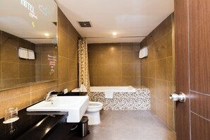 Ein modernes Badezimmer mit großem Spiegel, Waschbecken, Toilette und Duschbereich.