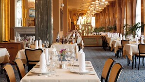 A formal dining room with tables set for service, featuring chandeliers and a fireplace. - ALEXANDRIA Spa & Wellness hotel (Luhacovice)
