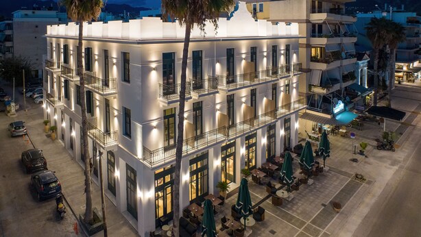 A multi-story hotel with balconies, outdoor seating, and a pool area. - Grand Hotel Kalamata (Kalamata)