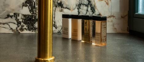 A gold-colored object on a marble countertop with a window in the background.