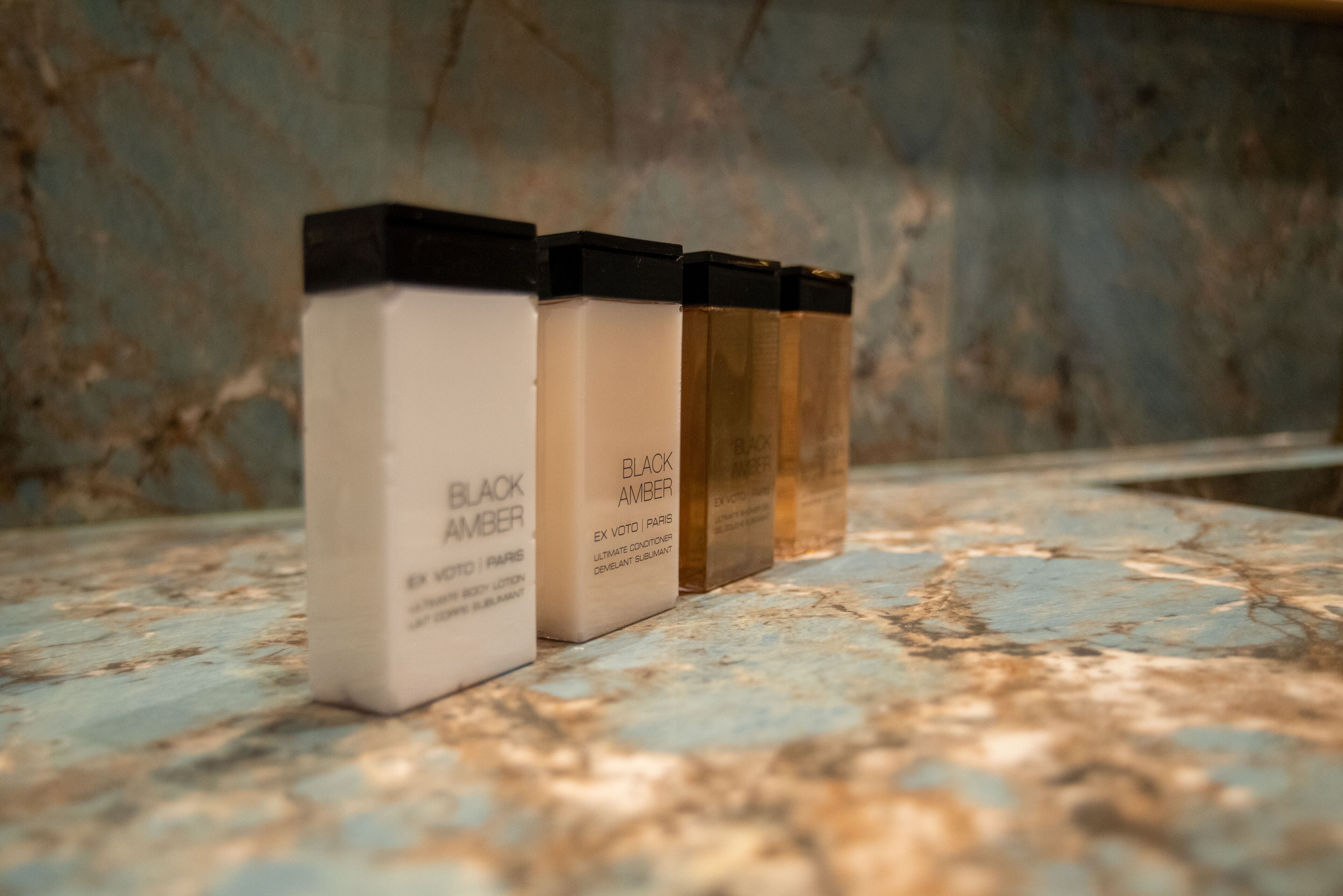 Three skincare products on a marble surface.