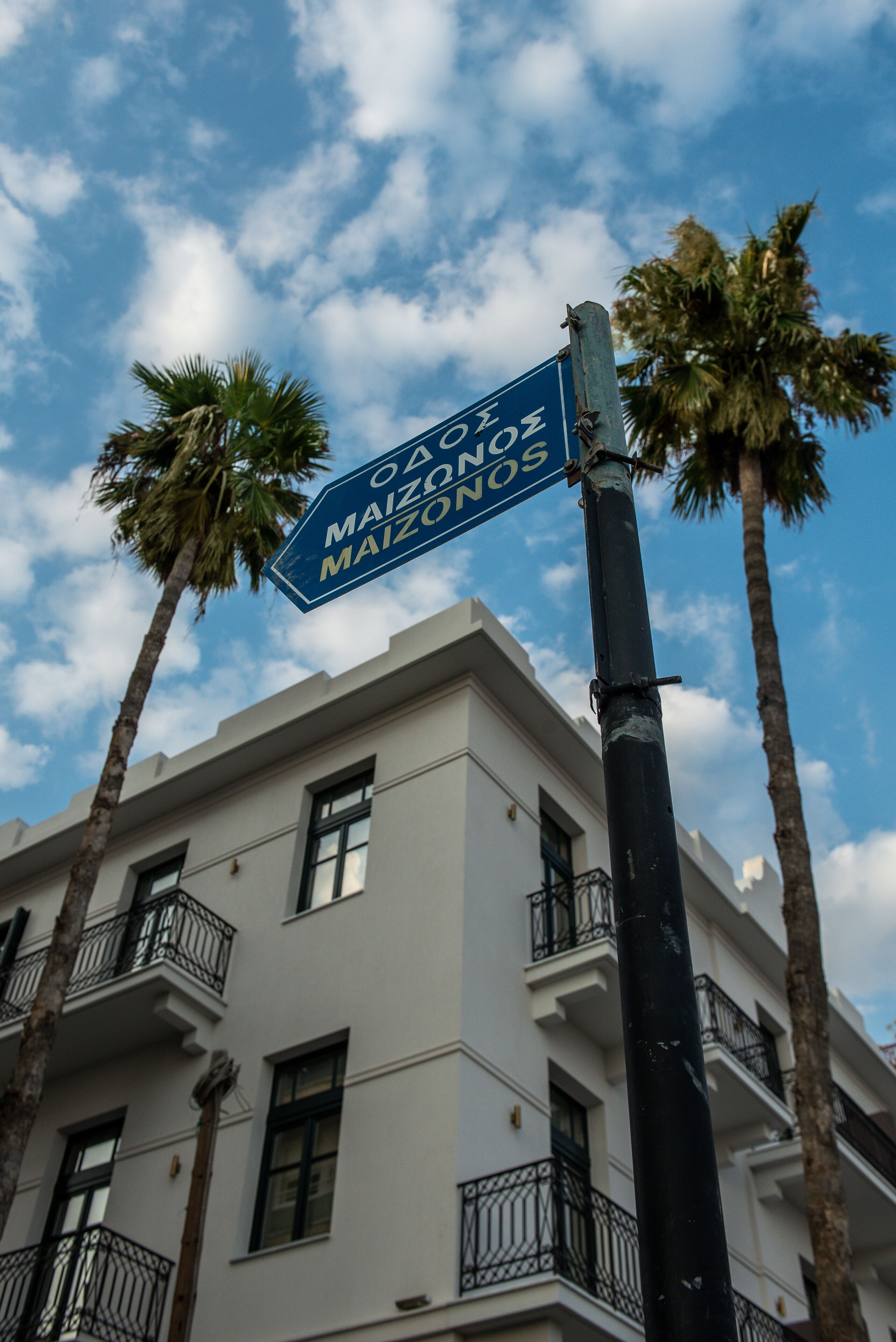 A street sign for "Odeon Maizones" with a building in the background.