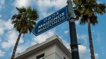 Una señal de calle para "Odeon Maizones" con un edificio al fondo.