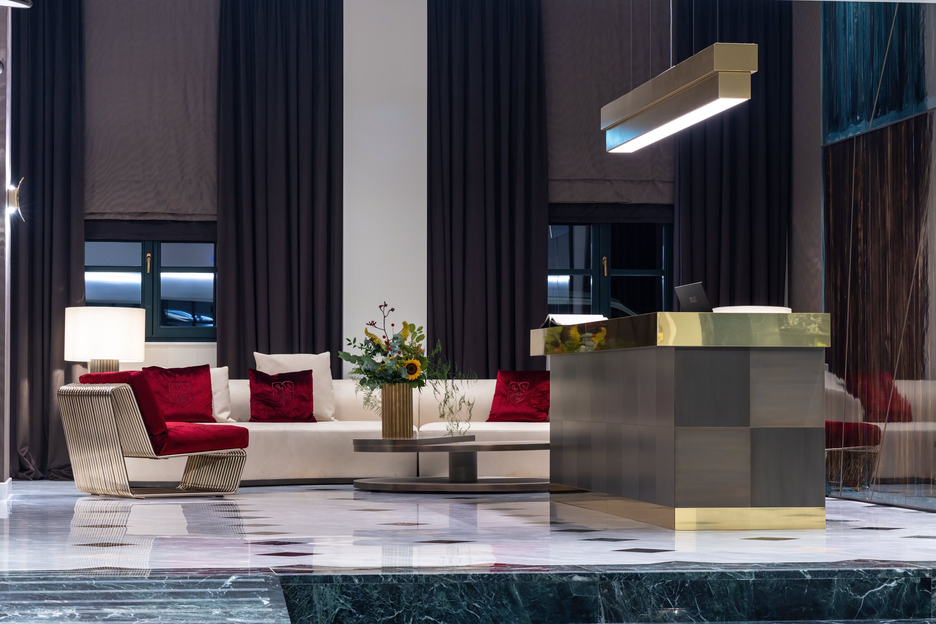 A modern lobby with a sofa, a coffee table, and a reception desk.