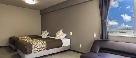 Un dormitorio con cama, sofá, ventana con cortinas y vista al cielo.