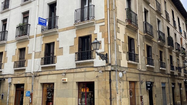 A multi-story building with balconies, a visible shop entrance, and a clear sky. - Pensión Gurtxu by Sun Sebastián (San Sebastián)