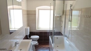 Bañera con ducha, secador de pelo, bidet, toallas