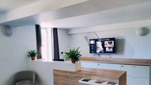 Una recepción con encimera de madera, una planta en maceta y un panel decorativo en la pared.
