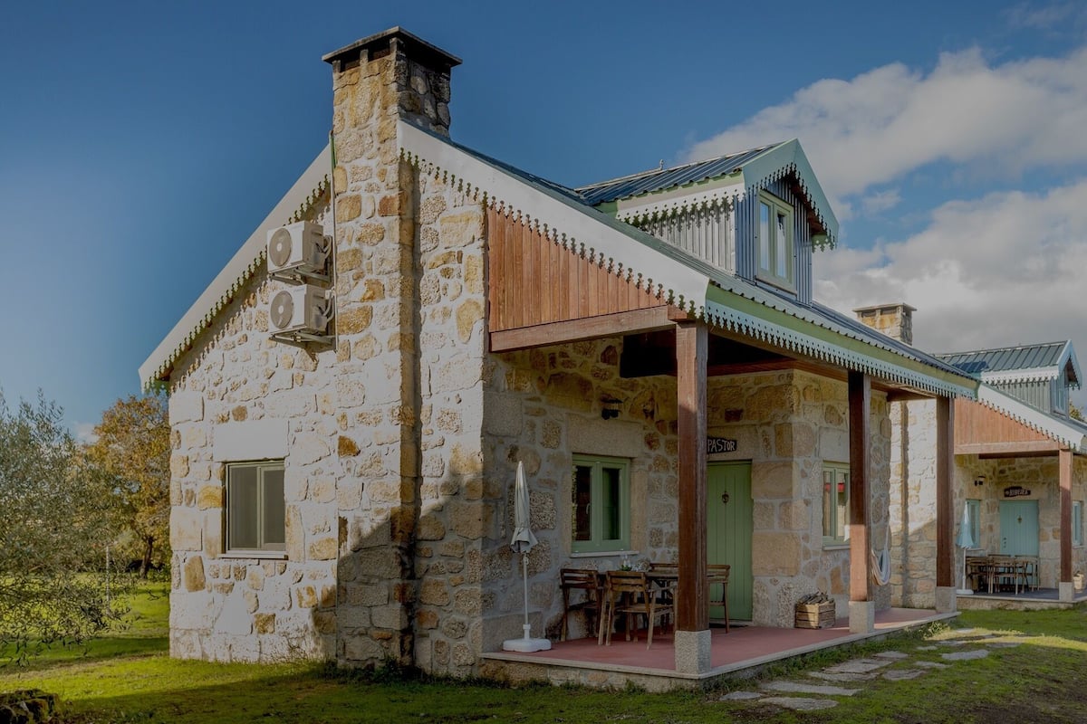 A stone building with a covered porch, a chimney, and a sign that reads "PIBERTA".
