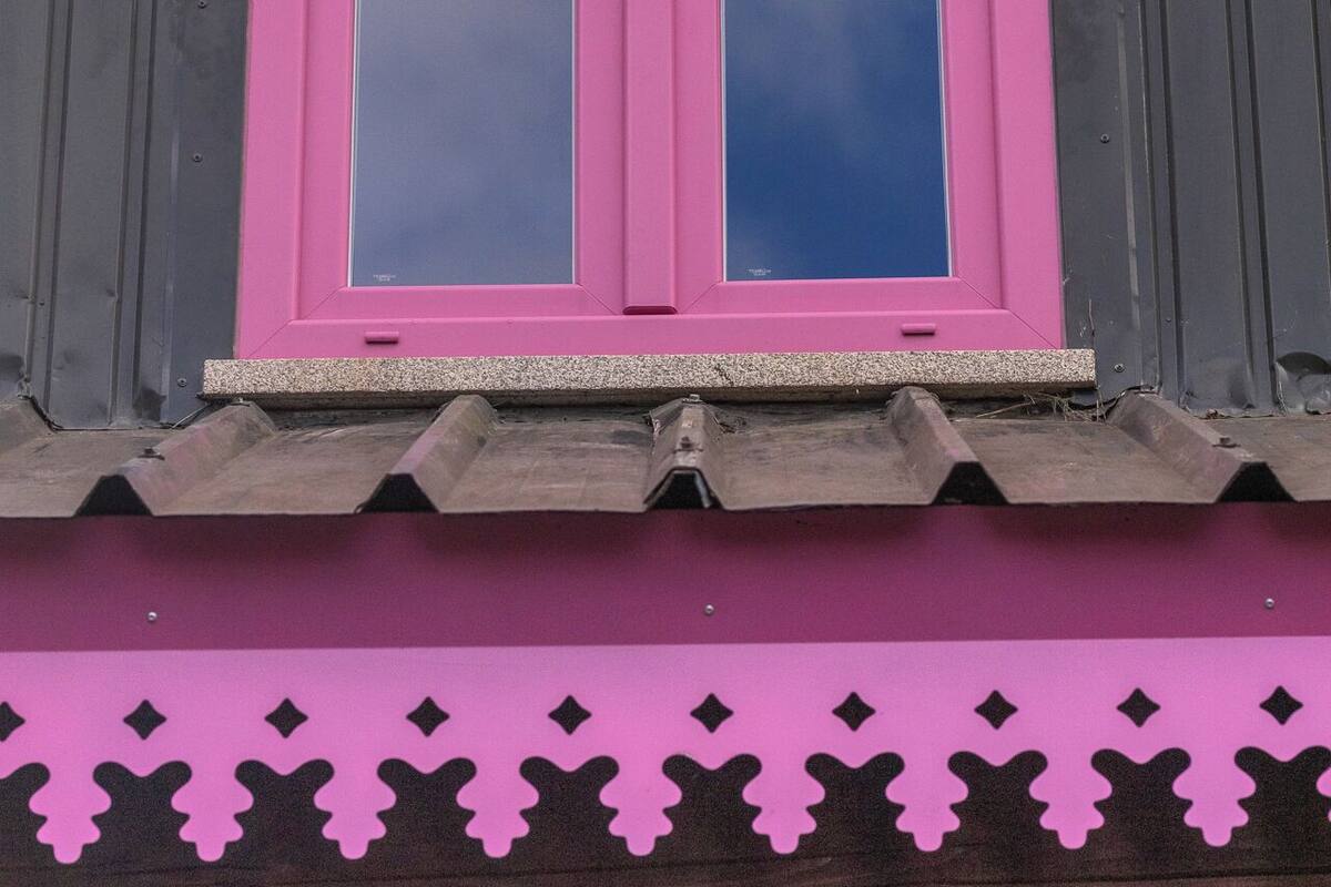 A building with a pink window and a pink roof.